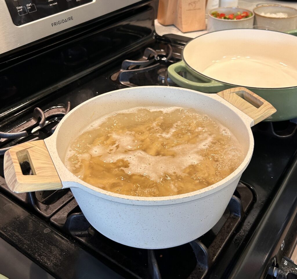 Penne pasta cooking in boiling water for creamy Cajun chicken pasta