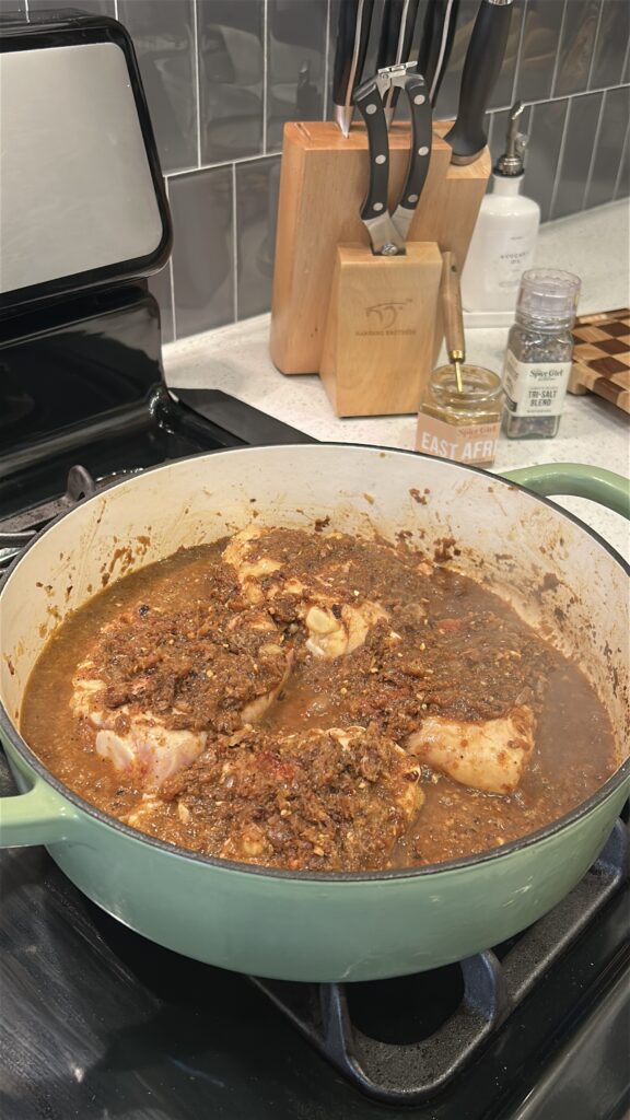 adding chicken to doro wat spice base in pot