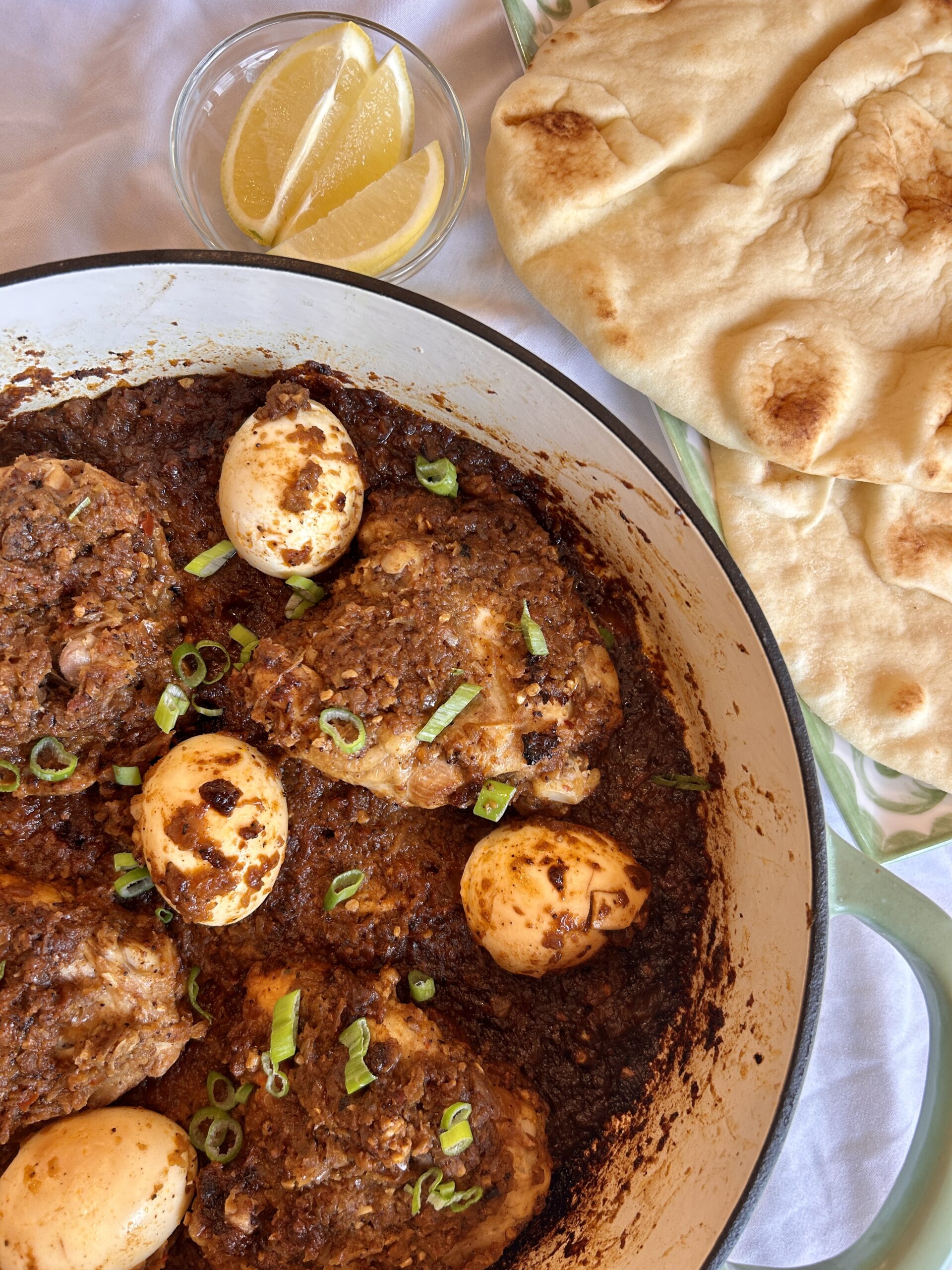close up of doro wat showing thick onion sauce coating chicken and eggs