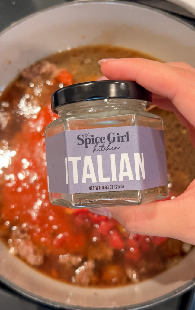 Adding Italian seasoning and basil to lasagna soup