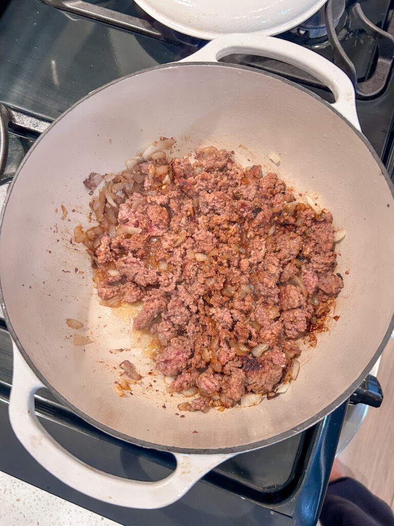Ground beef browning in a pot for lasagna soup