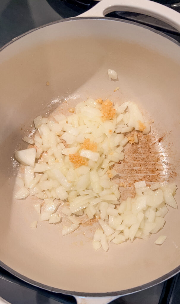 Onion and garlic sautéing in a pot for lasagna soup