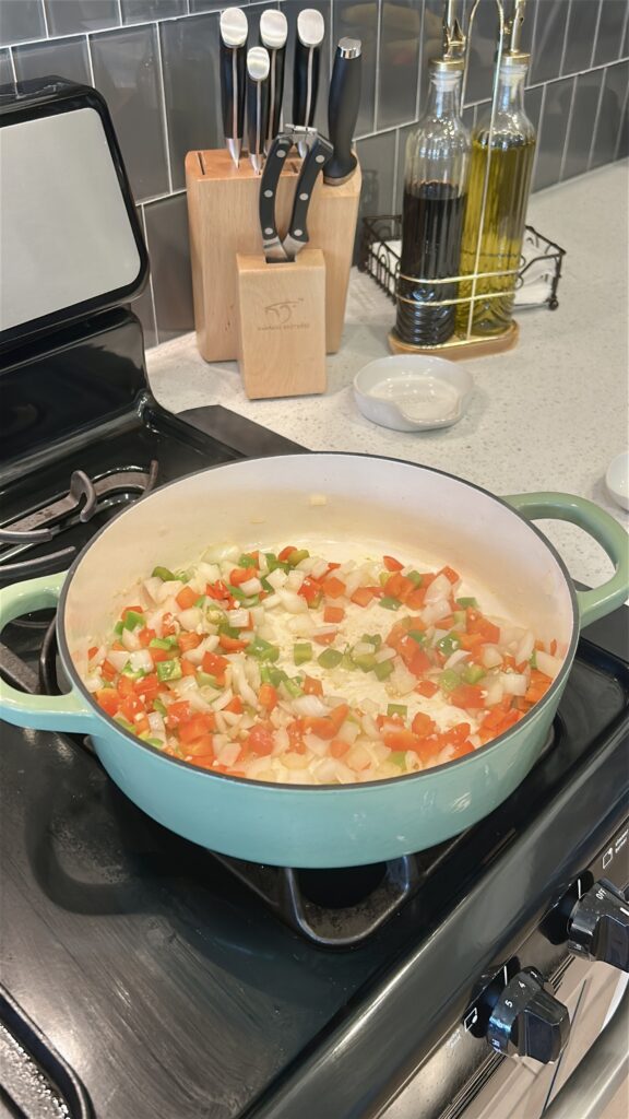 Onion and bell peppers sautéing for Cuban shrimp creole sauce