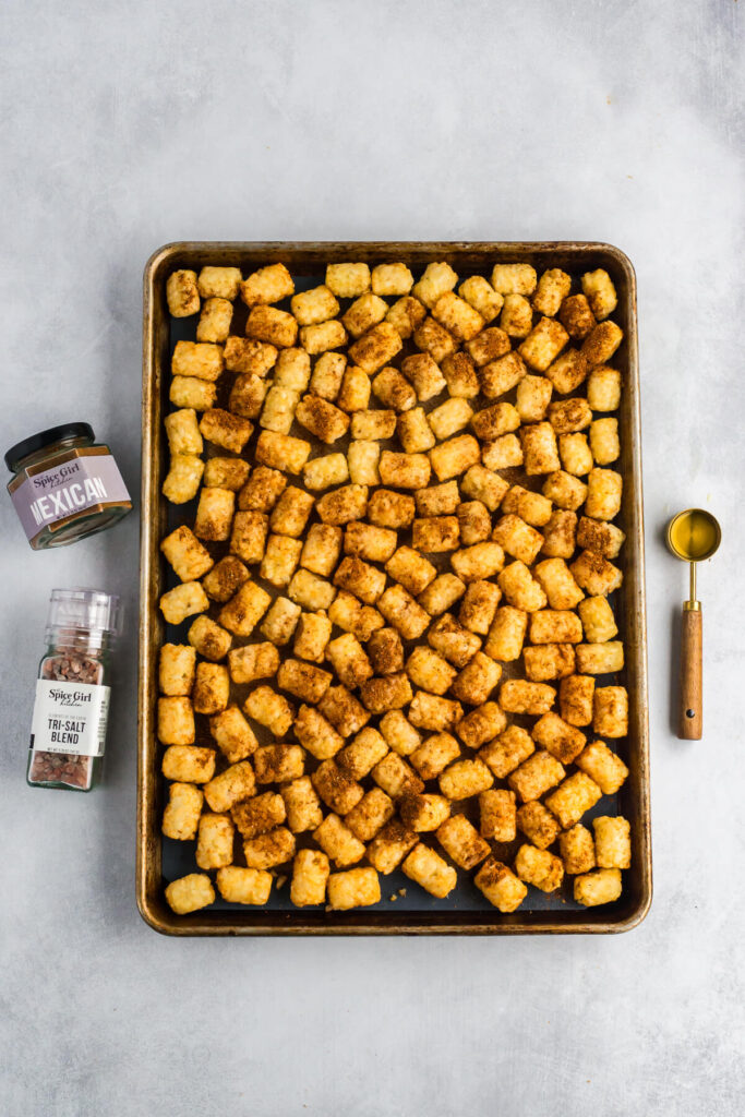 Tater tots arranged in a single layer on a sheet pan