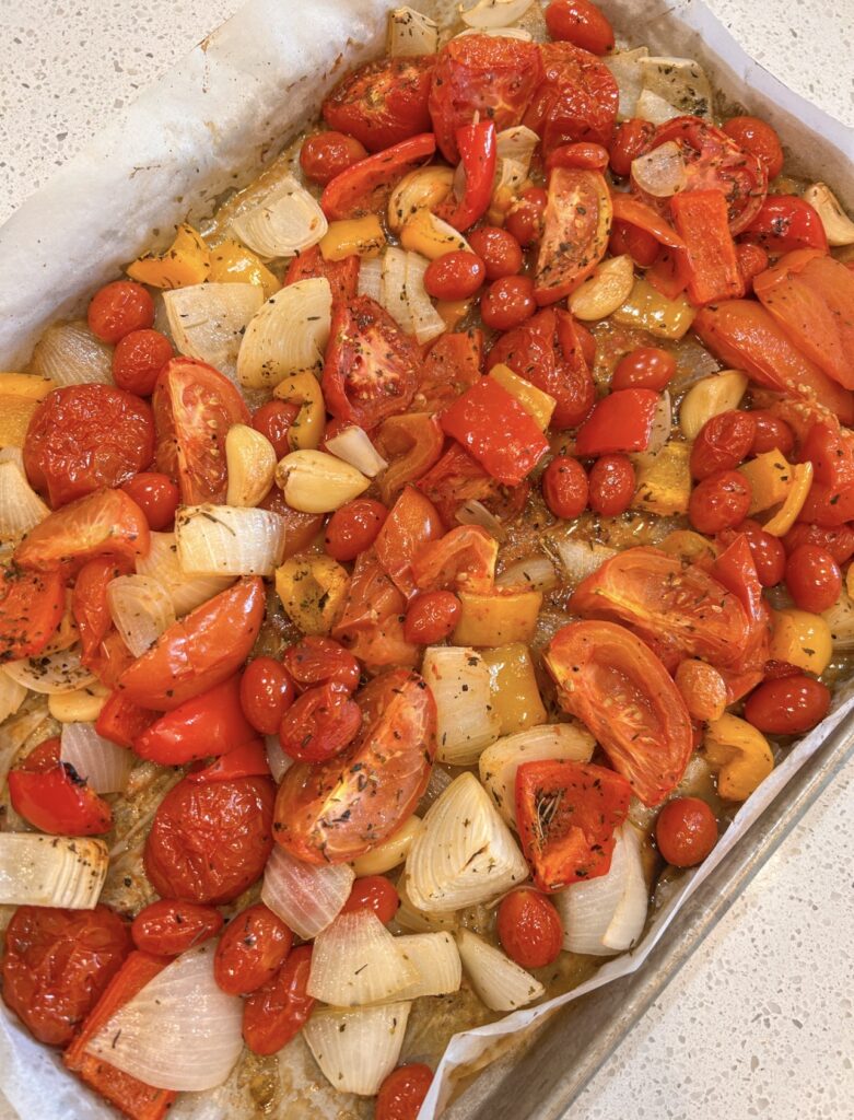Roasted tomatoes, red peppers, onions, and garlic caramelized on a sheet pan