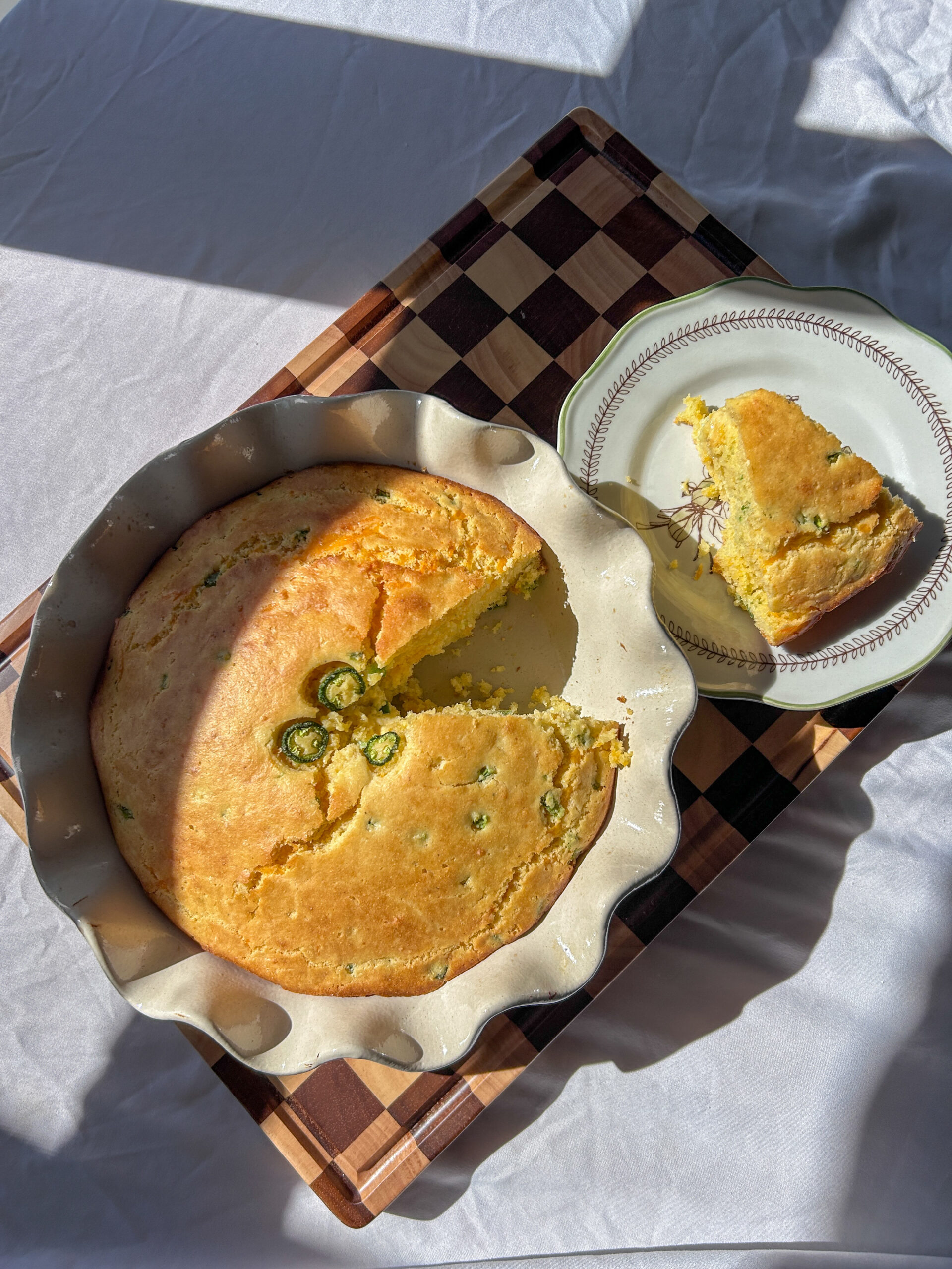 Jalapeño cheddar cornbread baked in 8-inch pie pan with butter melting on top