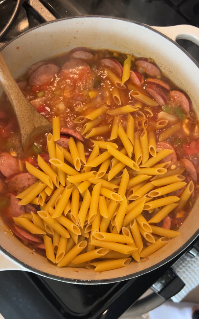 adding penne pasta to cajun pastalaya