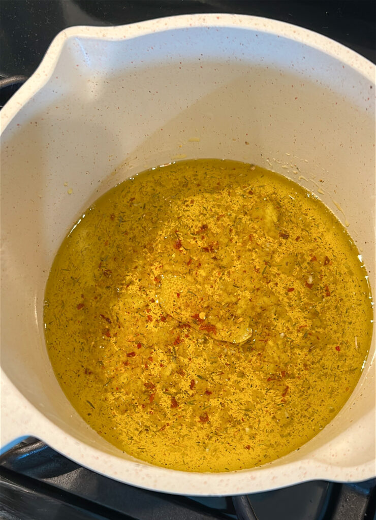 adding vinegar to warm olive oil