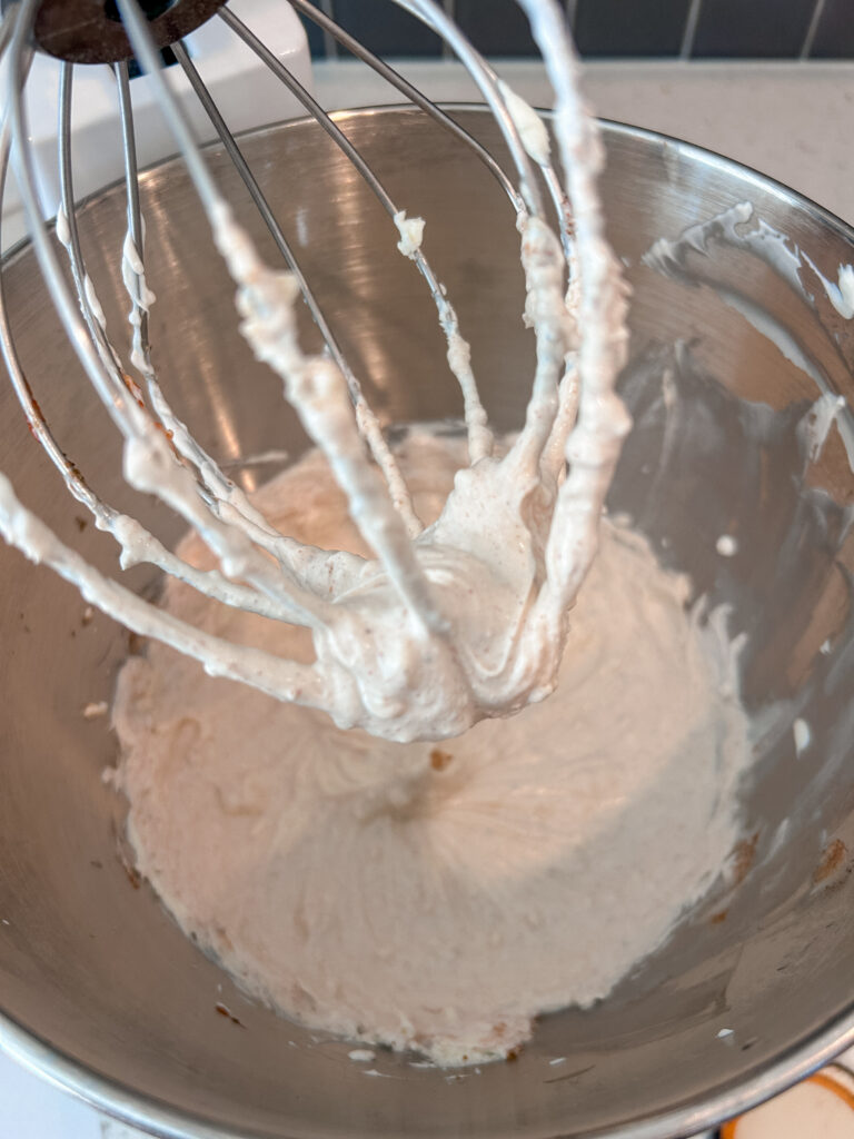 Mixing tomato, horseradish, and Cajun seasoning into creamy dip base