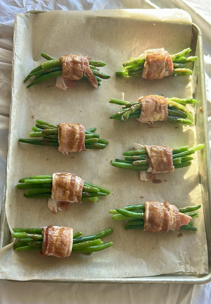 Brushing glaze onto bacon wrapped green bean bundles before baking