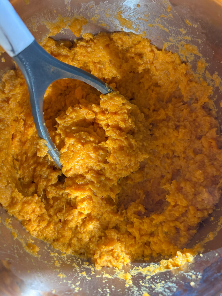 mashing sweet potatoes with butter and cream inside instant pot