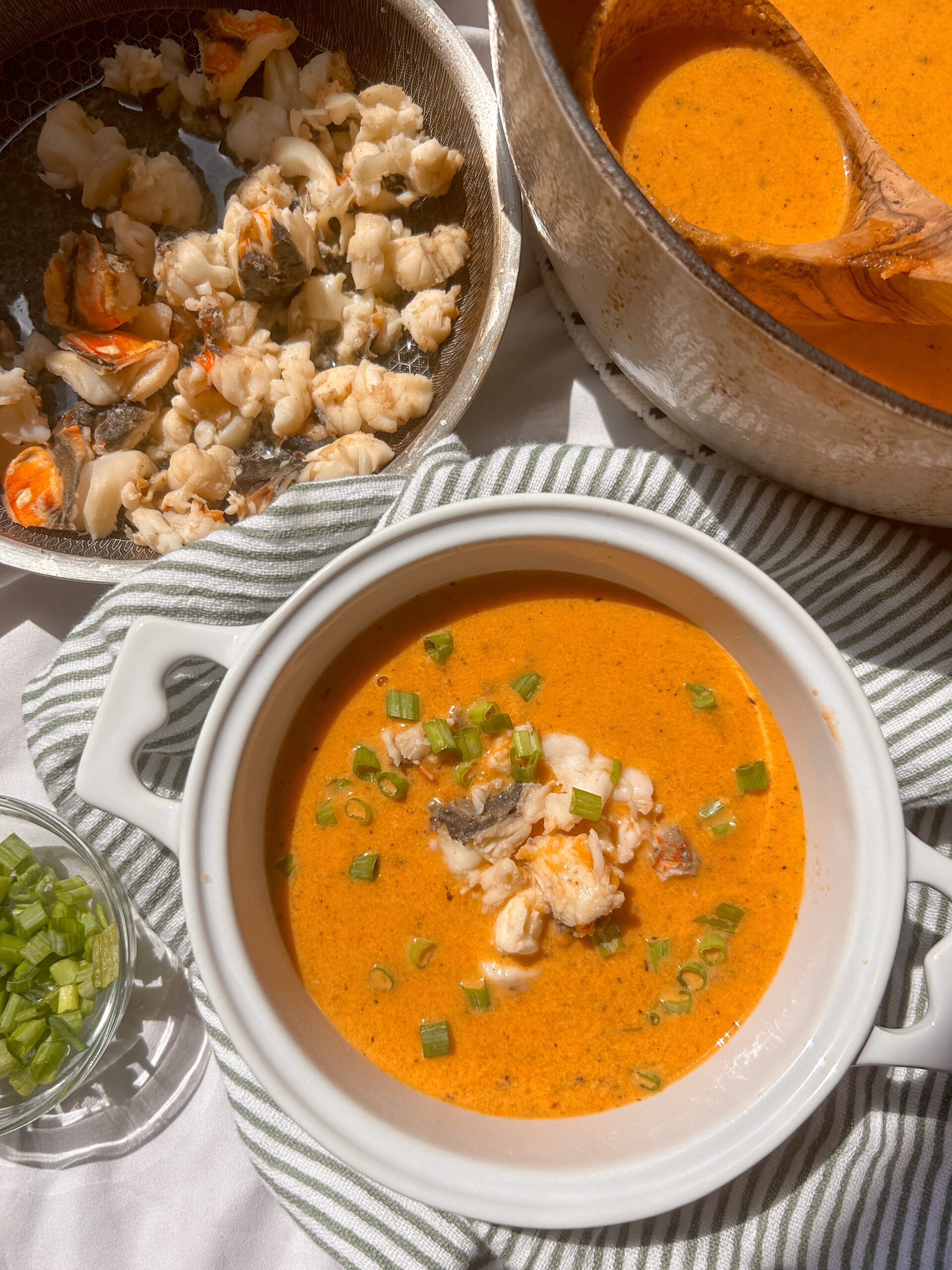 Creamy lobster bisque topped with pieces of lobster and fresh herbs