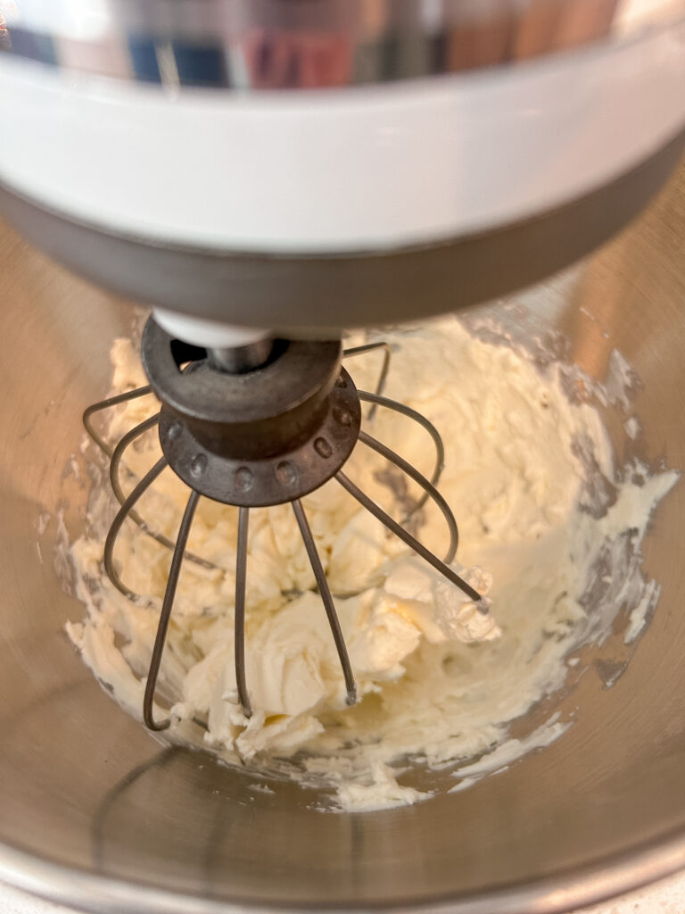Beating cream cheese until smooth for a cold party dip