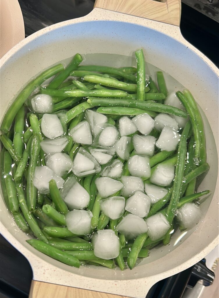Shocking green beans in ice water to stop cooking