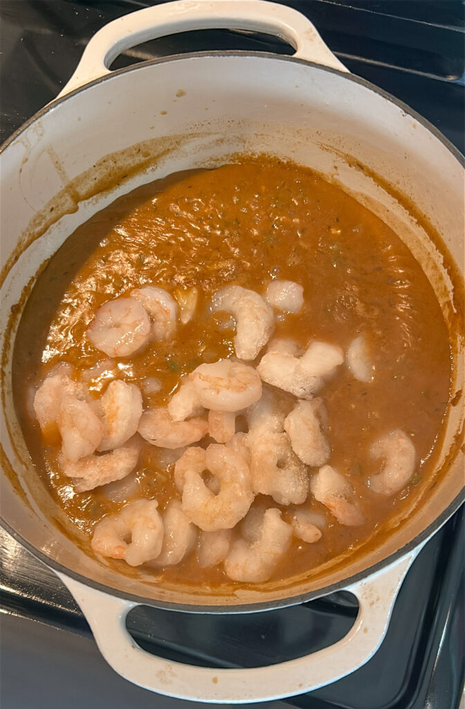 Adding shrimp to the thickened etouffee gravy for shrimp etouffee