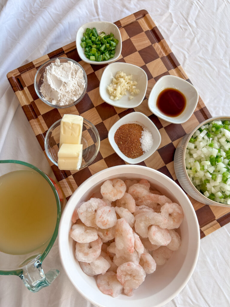 Ingredients for shrimp etouffee including onion, celery, bell pepper, shrimp, butter, flour, broth, and Cajun seasoning