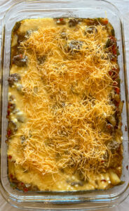 Shredded cheese added to breakfast burrito egg bake