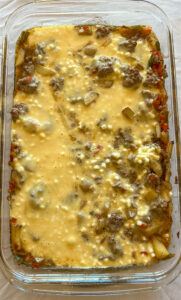 Pouring egg mixture over vegetables and meat