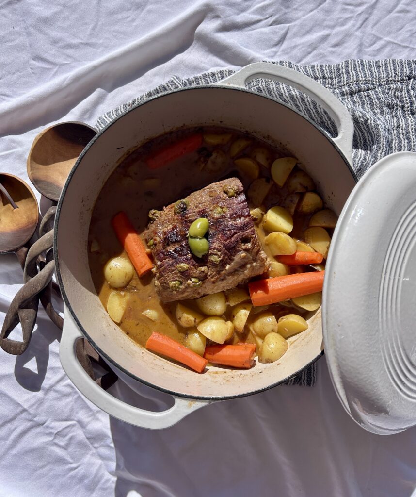 Adding potatoes and carrots to boliche criollo during braising
