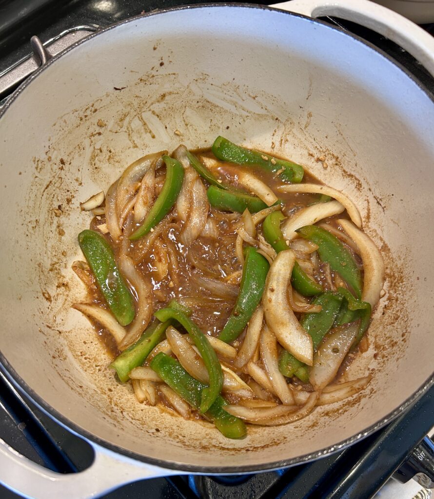 Building the braising sauce for boliche criollo with onions, peppers, and citrus