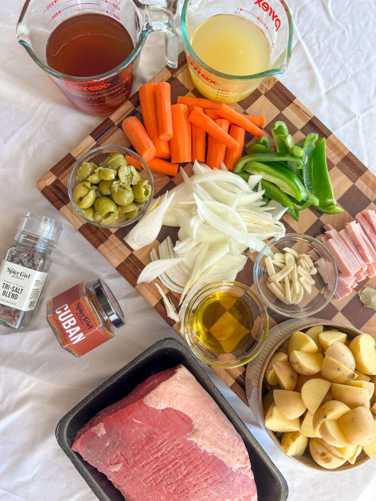 Ingredients for boliche criollo including eye of round beef, chorizo, garlic, olives, and citrus