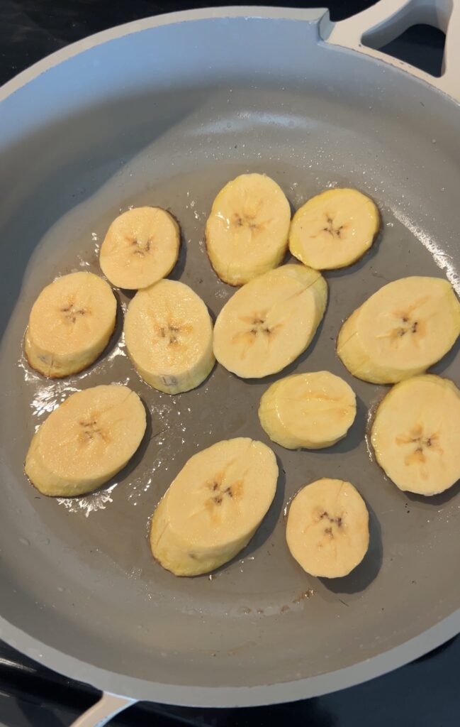 Frying sweet plantains on the first side until golden