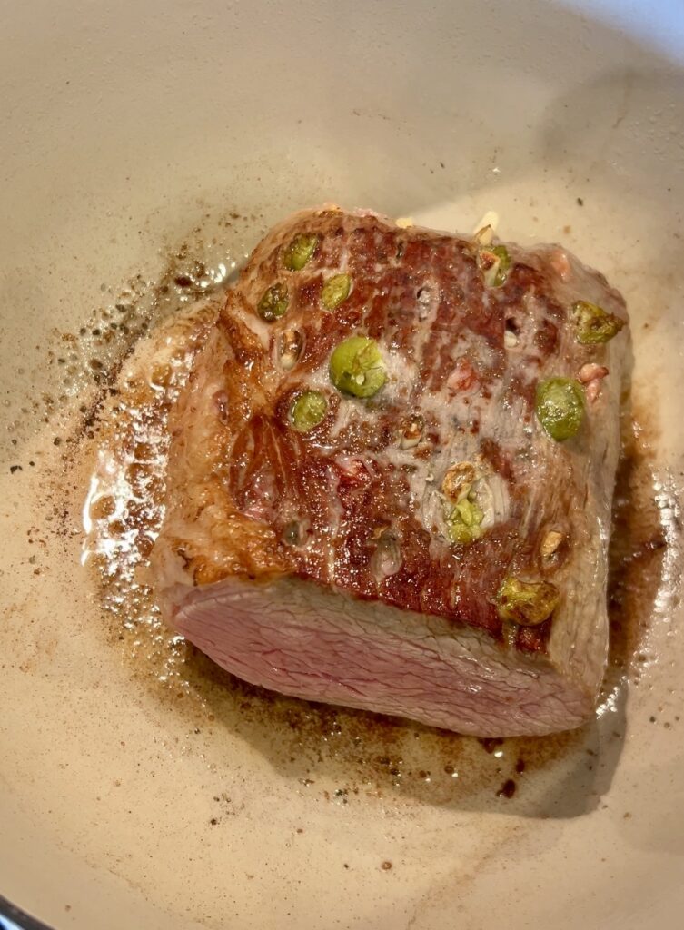 Searing stuffed boliche roast in a Dutch oven