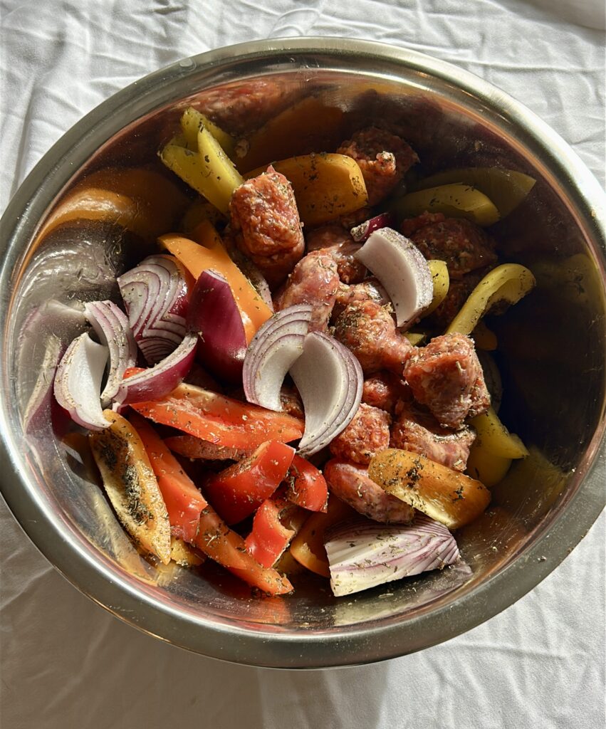 seasoning sausage peppers and onions with Italian seasoning before roasting