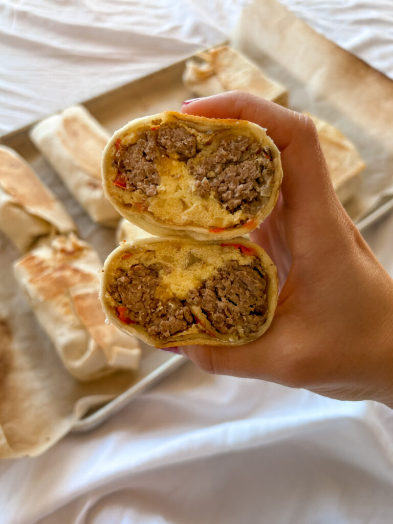 Crispy sheet pan breakfast burrito sliced open with egg and potato filling