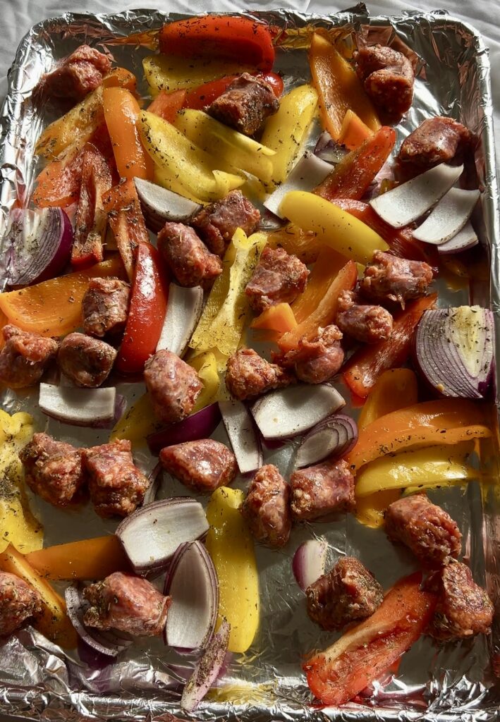 sheet pan sausage peppers and onions before roasting in the oven