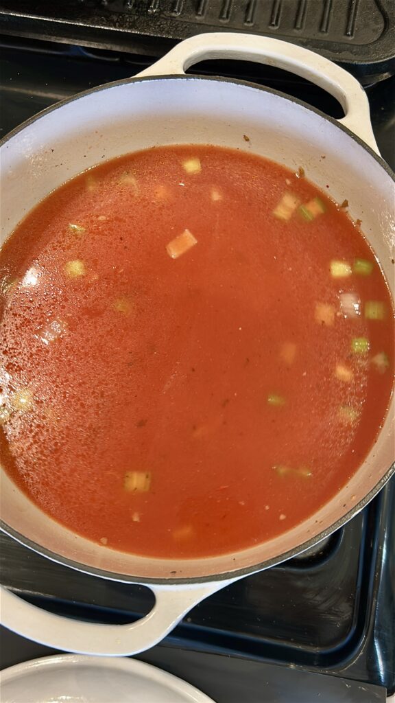 Simmering tomato broth for traditional pasta fagioli