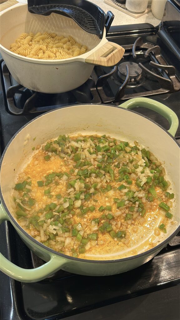 Onion, bell pepper, and Cajun seasoning cooking in butter
