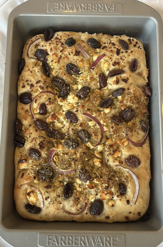 Freshly baked Greek focaccia with golden crust and melted feta