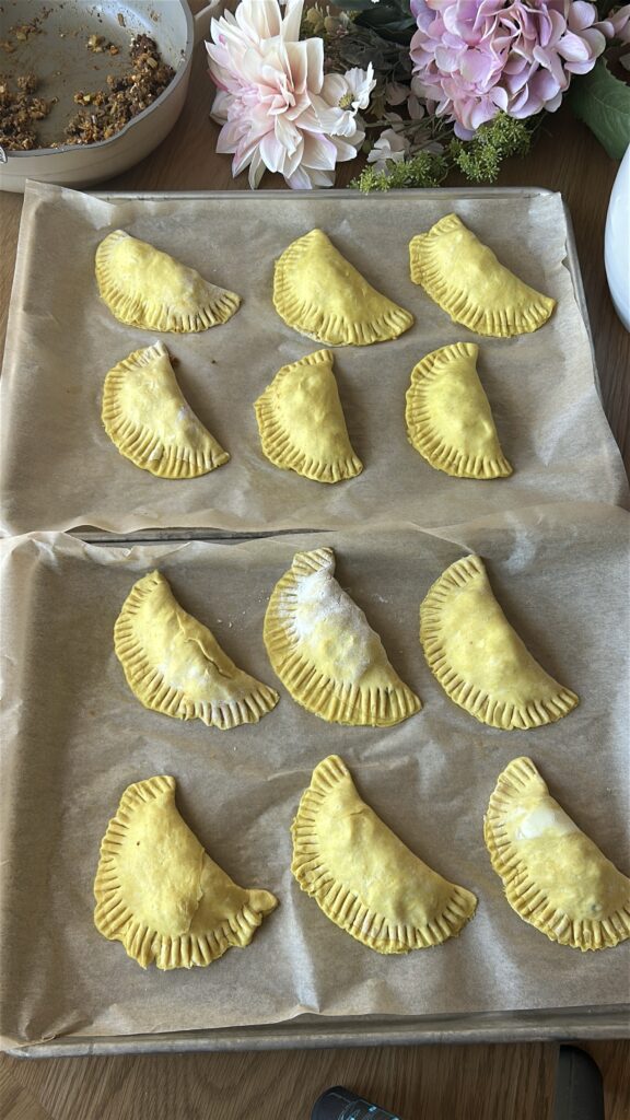 Crimping edges of Jamaican meat pie before baking