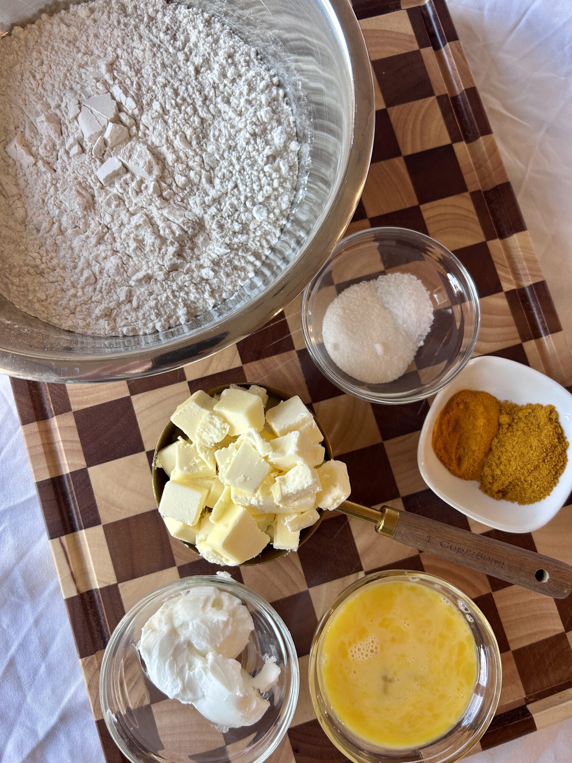Pastry ingredients for Jamaican meat pie recipe including flour, turmeric, butter, and curry powder