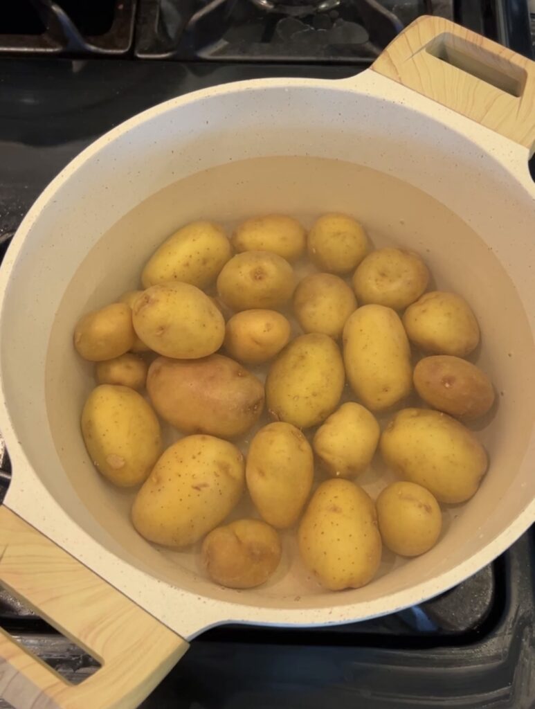 baby potatoes boiling in salted water before smashing
