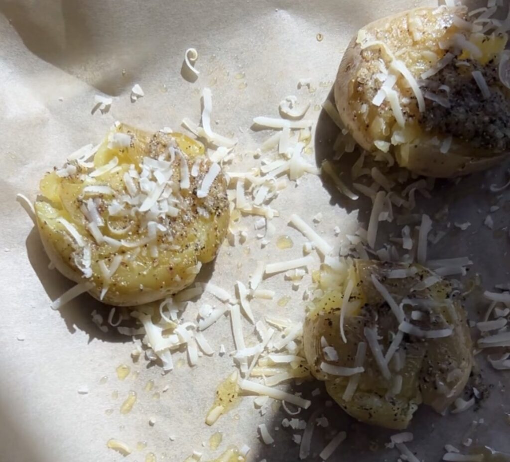 brushing garlic oil and parmesan over smashed potatoes before roasting