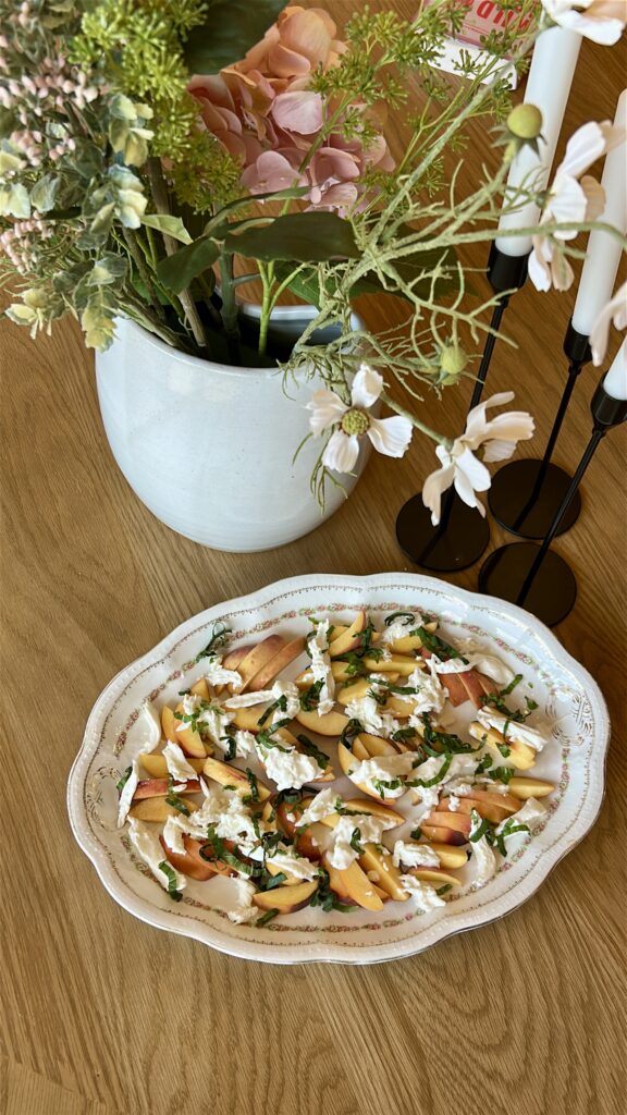 Adding fresh basil to peach caprese salad