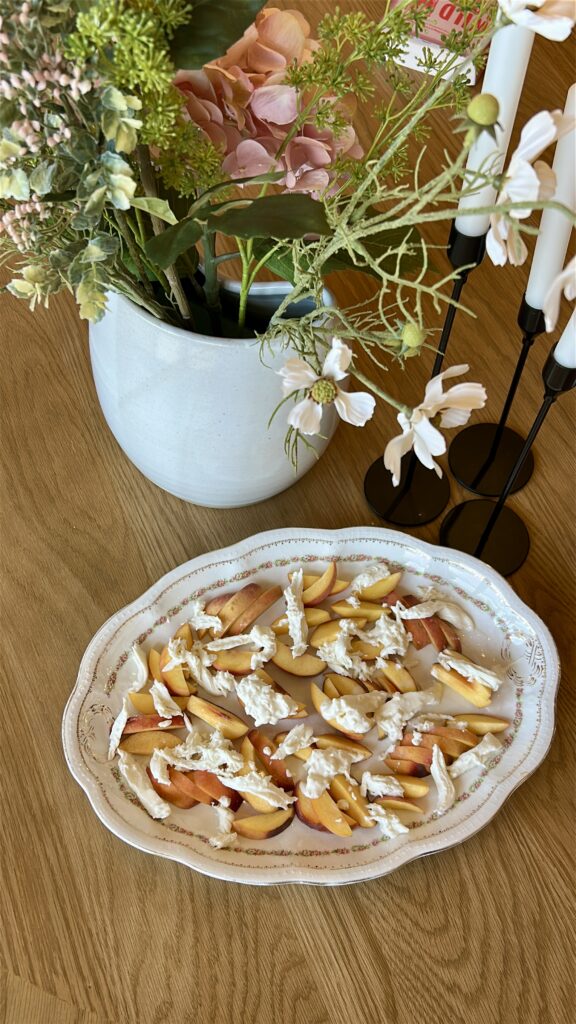 Adding burrata to peach caprese salad