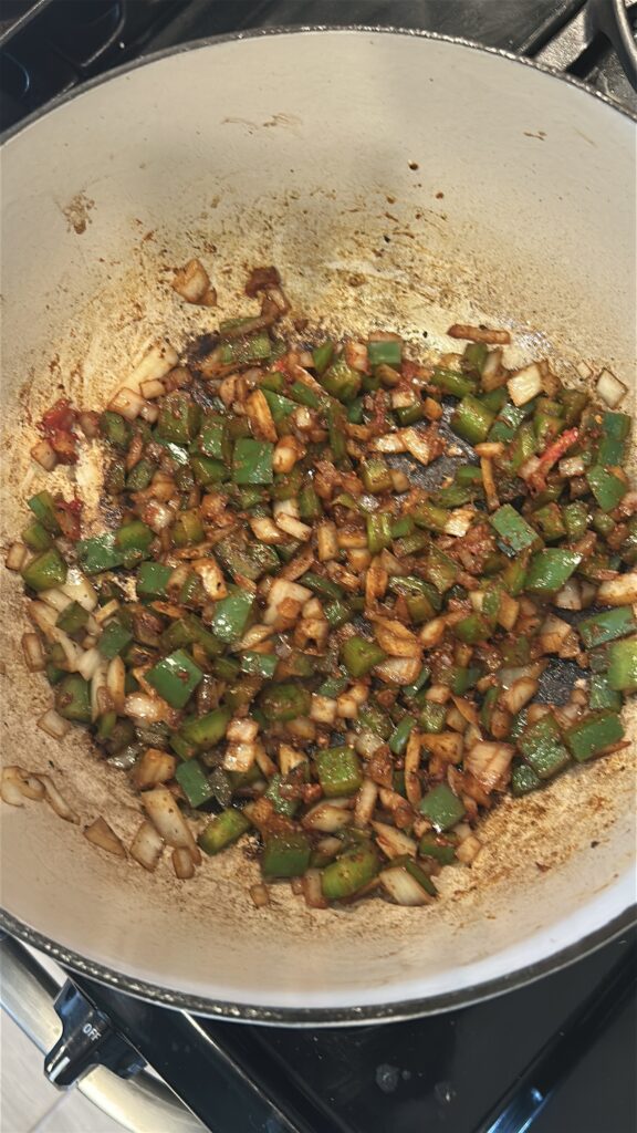 Cooking sofrito base with onion and bell pepper for carne guisada