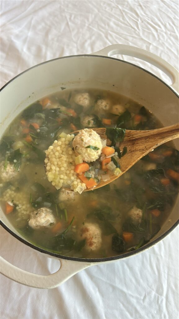 close up of italian wedding soup with turkey meatballs pasta and spinach