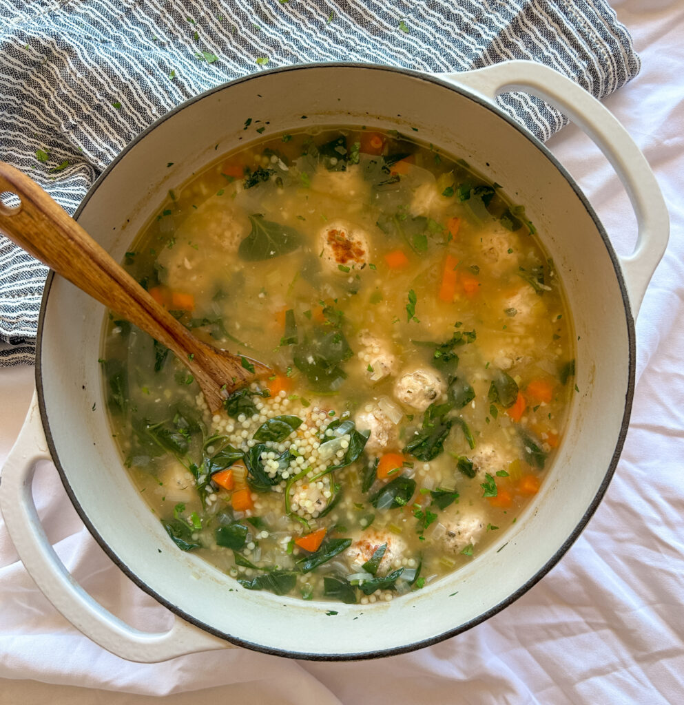 Italian wedding soup with turkey meatballs, spinach, and pasta in a parmesan broth