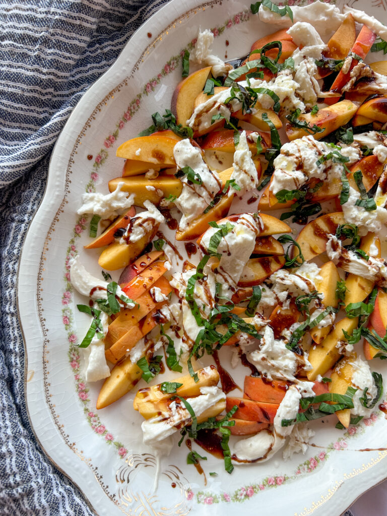 Close up of burrata on peach caprese salad