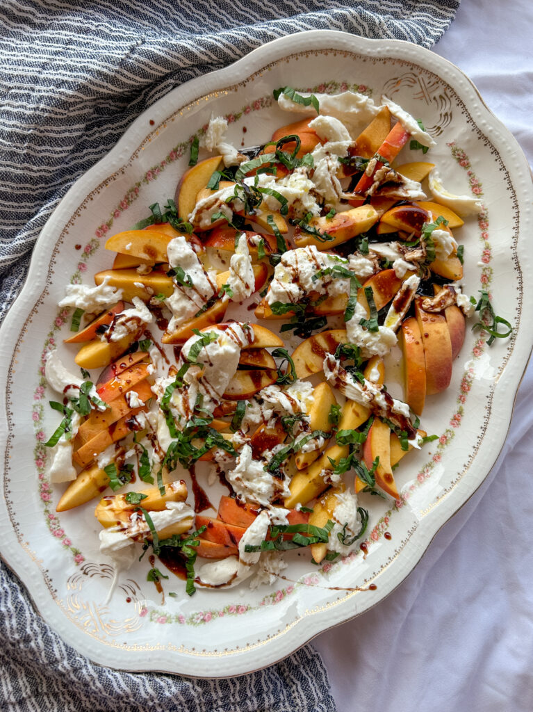 Serving peach caprese salad with burrata and basil