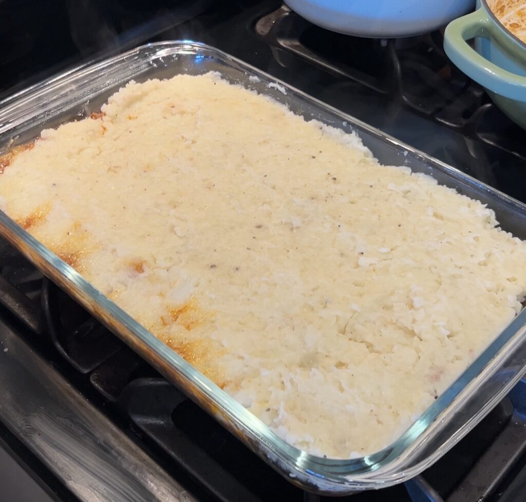 Assembled shepherd’s pie with mash spread over lamb filling before baking