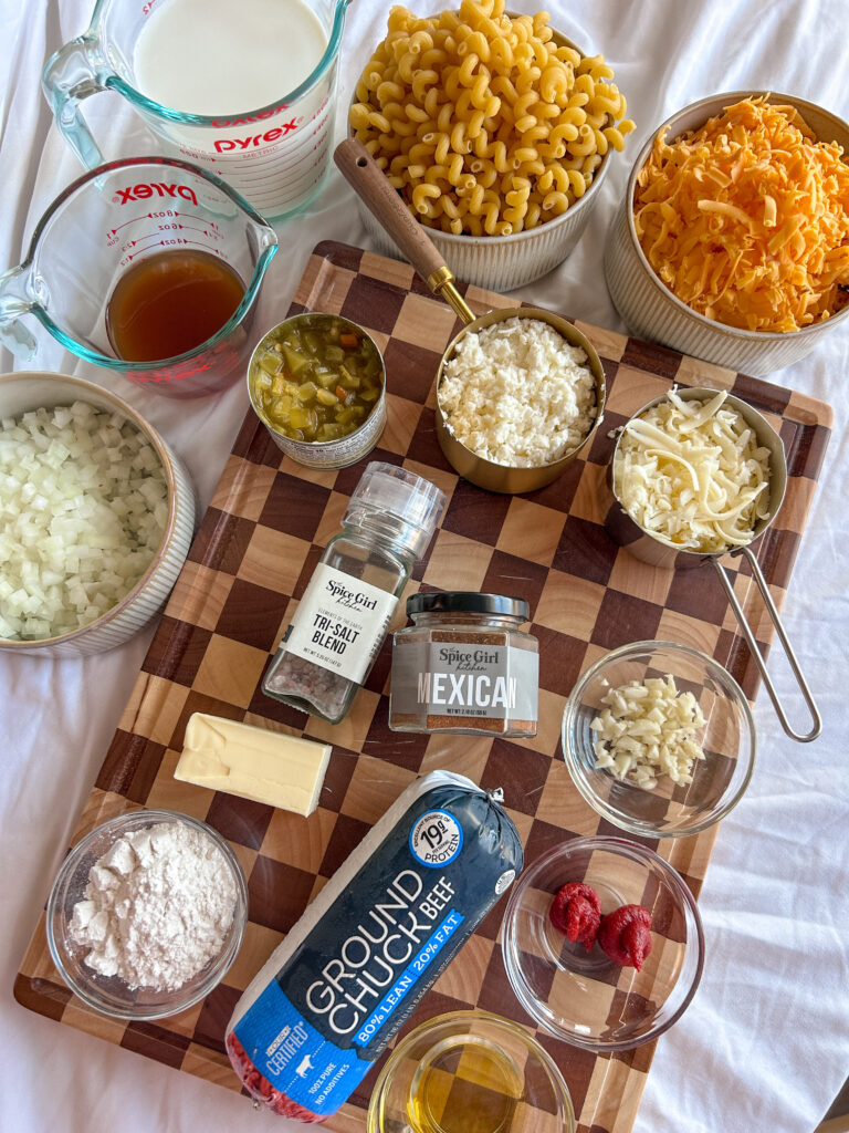 ingredients for taco mac and cheese including ground beef, cellentani pasta, shredded cheese, and Mexican seasoning