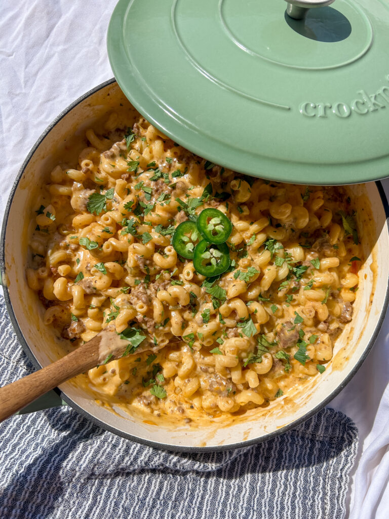 taco mac and cheese in a skillet with melted cheese and toppings