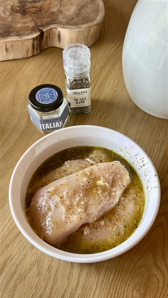 Adding Italian seasoning and garlic to chicken marinade