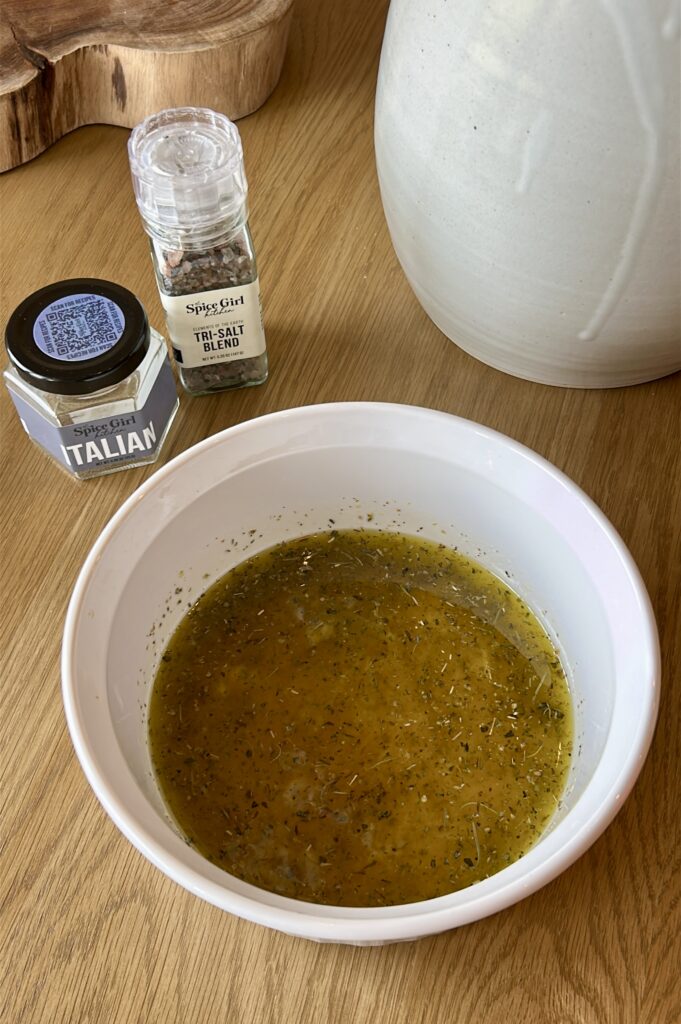 Adding Italian seasoning and garlic to chicken marinade