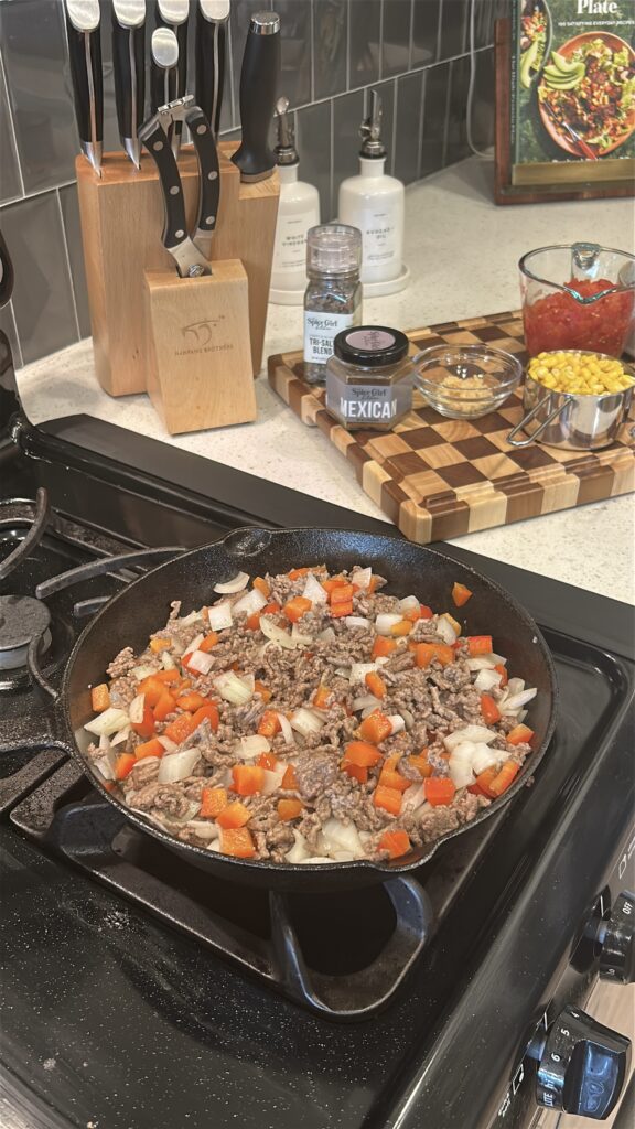 cooking ground beef with onions and peppers for mexican cornbread casserole